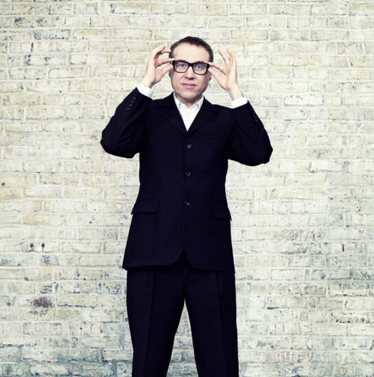 Jean-François Zygel debout qui réajuste ses lunettes